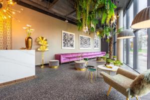 ein Wohnzimmer mit rosa Sofas und Pflanzen in der Unterkunft Hotel Zoo by Afrykarium Wroclaw in Breslau