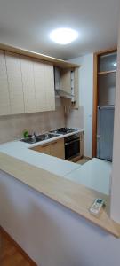 a kitchen with white cabinets and a counter top at Apartman Fran in Zagreb