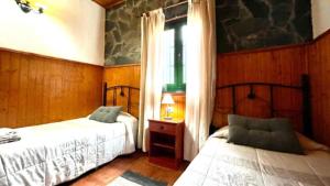 1 dormitorio con 2 camas y ventana en Casa Rural Ondina, en Hermigua