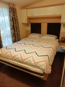 a bedroom with a bed with a white comforter at Chalet op de Holterberg in Holten