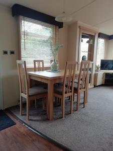 a dining room table with chairs and a vase on it at Chalet op de Holterberg in Holten