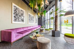 a living room with a purple couch and a table at Hotel Zoo by Afrykarium Wroclaw in Wrocław