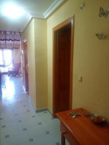 a room with a table and a hallway with a door at apart playa Tano in La Mata