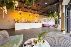 a lobby with a table and chairs and plants at Hotel Zoo by Afrykarium Wroclaw in Wrocław