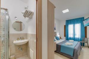 a bedroom with a bed and a sink and a mirror at NottInCentro -Guest House- in Sciacca
