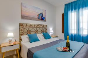 a bedroom with a bed with a tray with a bottle of wine at NottInCentro -Guest House- in Sciacca