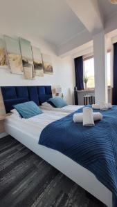 2 Betten in einem Schlafzimmer mit blau und weiß in der Unterkunft White Beach 211 in Mielno