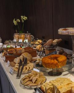 a table filled with different types of bread and pastries at Art Hotel Transamerica Collection in Porto Alegre
