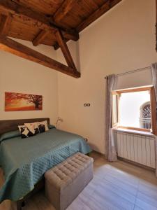 a bedroom with a bed and a large window at La finestra sul cortile by TraMonti Apartments in LʼAquila