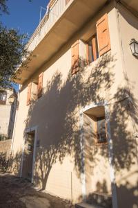 una sombra de un árbol al lado de un edificio en a Casa, en Calenzana