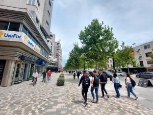 a group of people walking down a city street at Redsun City Center Apartment in Vlorë +12 photos