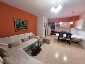 a living room with a couch and a table at Redsun City Center Apartment in Vlorë