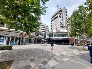 a street in a city with tall buildings at Redsun City Center Apartment in Vlorë