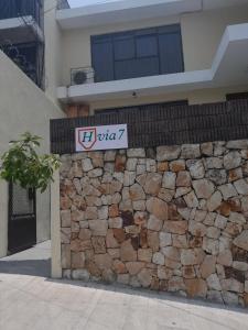 ein Schild an einer Steinmauer vor einem Haus in der Unterkunft Hospedaje Via 7 in Guatemala