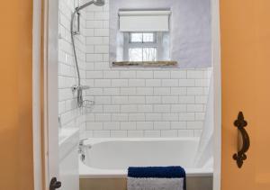 La salle de bains est pourvue d'une baignoire blanche et d'une fenêtre. dans l'établissement The Snug, à Hawes