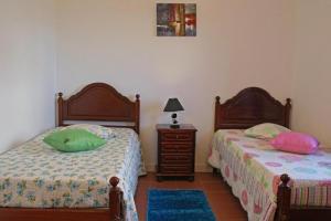 dos camas sentadas una al lado de la otra en un dormitorio en Casas da Boa Vista, en Horta
