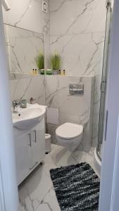 ein weißes Badezimmer mit Waschbecken und Toilette in der Unterkunft White Beach 211 in Mielno + 18 Fotos