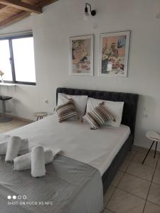 a white bedroom with a large bed with pillows at Vetti Rooms in Skiathos