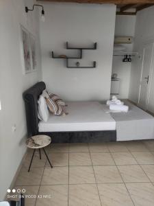 a bedroom with a large bed and a chair at Vetti Rooms in Skiathos