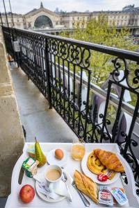 a table with breakfast food and coffee on a balcony at Hôtel D'Alsace in Paris