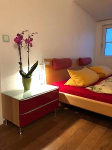 een slaapkamer met 2 bedden en een vaas met bloemen op een tafel bij Moderne Wohnung 15min International Airport Messe DÜS in Willich
