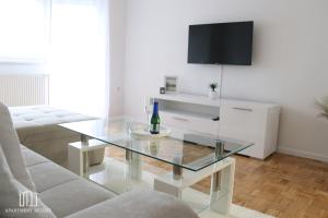 sala de estar con mesa de cristal y TV en Apartment Deluxe, en Jajce