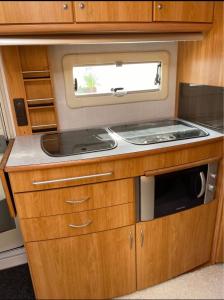 a kitchen in an rv with a sink and a window at Caravan on nice garden in Örebro