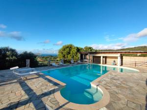 a swimming pool with a stone patio and blue water at Casa del Duca Portoferraio in Portoferraio