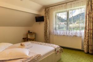 una camera da letto con un letto e una finestra di Vila Rustica a Moieciu de Sus