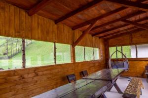 una sala da pranzo con tavolo e altalena di Vila Rustica a Moieciu de Sus