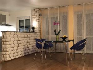a dining room with a table and blue chairs at Moderne Wohnung 15min International Airport Messe DÜS in Willich