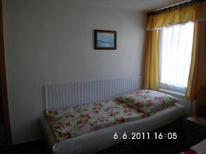 1 dormitorio con 1 cama con colcha de flores y ventana en Ferienwohnung Fehrmann, en Sassnitz