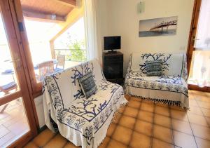 sala de estar con 2 sillas y TV en Villetta Elisa Best Vacation Ever Sant'Elmo, en Costa Rei