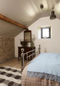1 dormitorio con cama y espejo en Kilquiggan Cottages en Coolkenna Street