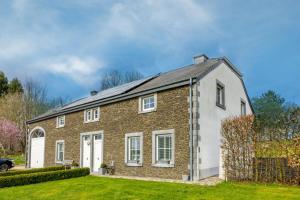 une maison en briques avec un toit en gambrel dans l'établissement Gîte Le Haut des Vannes, à Neufchâteau