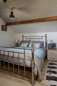 a bedroom with a bed with a blue comforter at Kilquiggan Cottages in Coolkenna Street