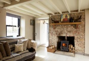 a living room with a brick fireplace and a couch at Kilquiggan Cottages in Coolkenna Street