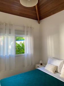 um quarto com uma cama e uma janela em Ao Mar - Hospedagem em São Sebastião
