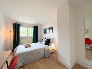 - une chambre avec un lit et une chaise rouge dans l'établissement Maison idéale pour visiter Paris Versailles - Chambres privées Paris-Saclay, à Bures-sur-Yvette