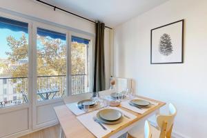 ein Esszimmer mit einem Tisch, Stühlen und einem Fenster in der Unterkunft Appartement 4 chambres 8 couchages avec extérieur in Marseille