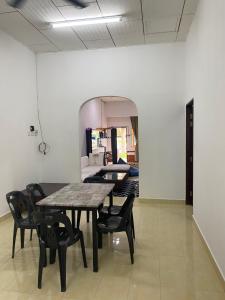 una sala da pranzo con tavolo e sedie nere di Simple1 Guesthouse a Pantai Cenang