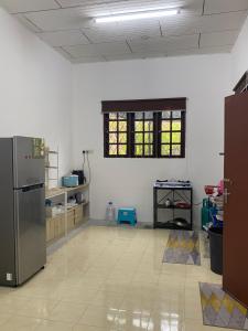 a large kitchen with a refrigerator in a room at Simple1 Guesthouse in Pantai Cenang