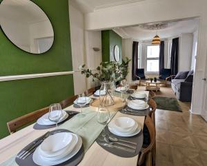 a dining room with a table and a green wall at Ocean Avenue in Plymouth