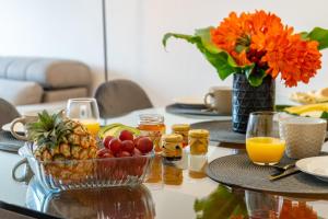 una mesa cubierta con un bol de fruta y zumo de naranja en JB Comfort Flat en Ponta Delgada