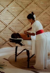 a woman sitting on a table with a man at Kan Tulum Hotel in Tulum