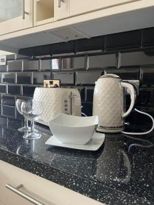 eine Küchentheke mit einer Teekanne und einer Schüssel darauf in der Unterkunft Beautifully presented Victorian Apartment within walking distance to Llandudno beach in Llandudno