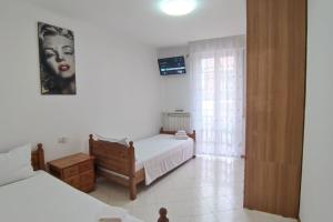 una camera con due letti e una foto di una donna di Elegante alloggio zona storica a Lecco
