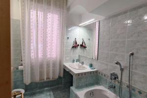 bagno con lavandino, vasca e specchio di Elegante alloggio zona storica a Lecco