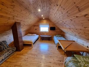 a room in a log cabin with a bed and a table at Gatiņi in Ventspils