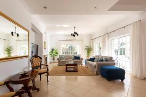 un soggiorno con divano e tavolo di Luxury Villa José with swimming pool a Quarteira